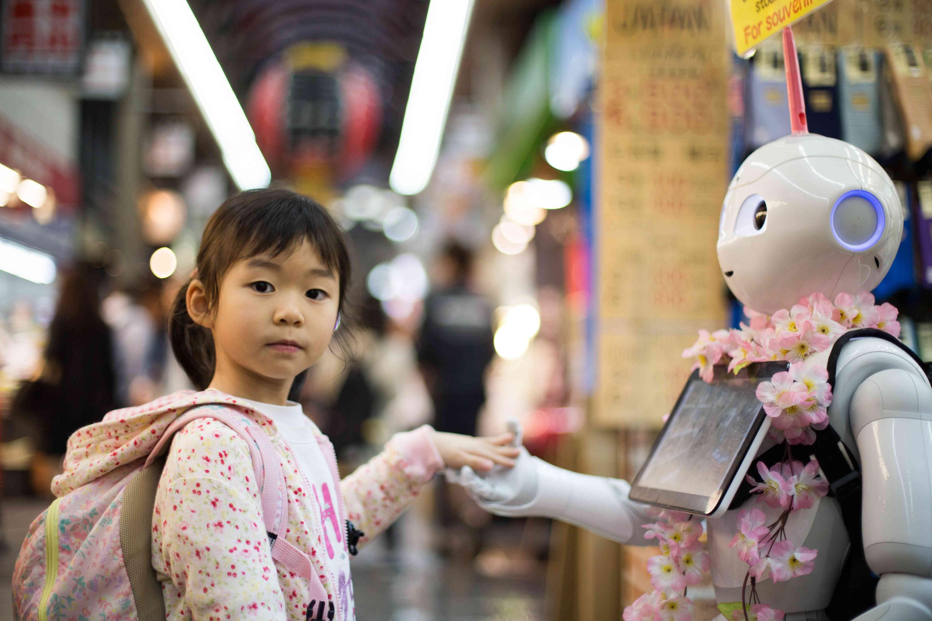 a girl shaking hand with a robot