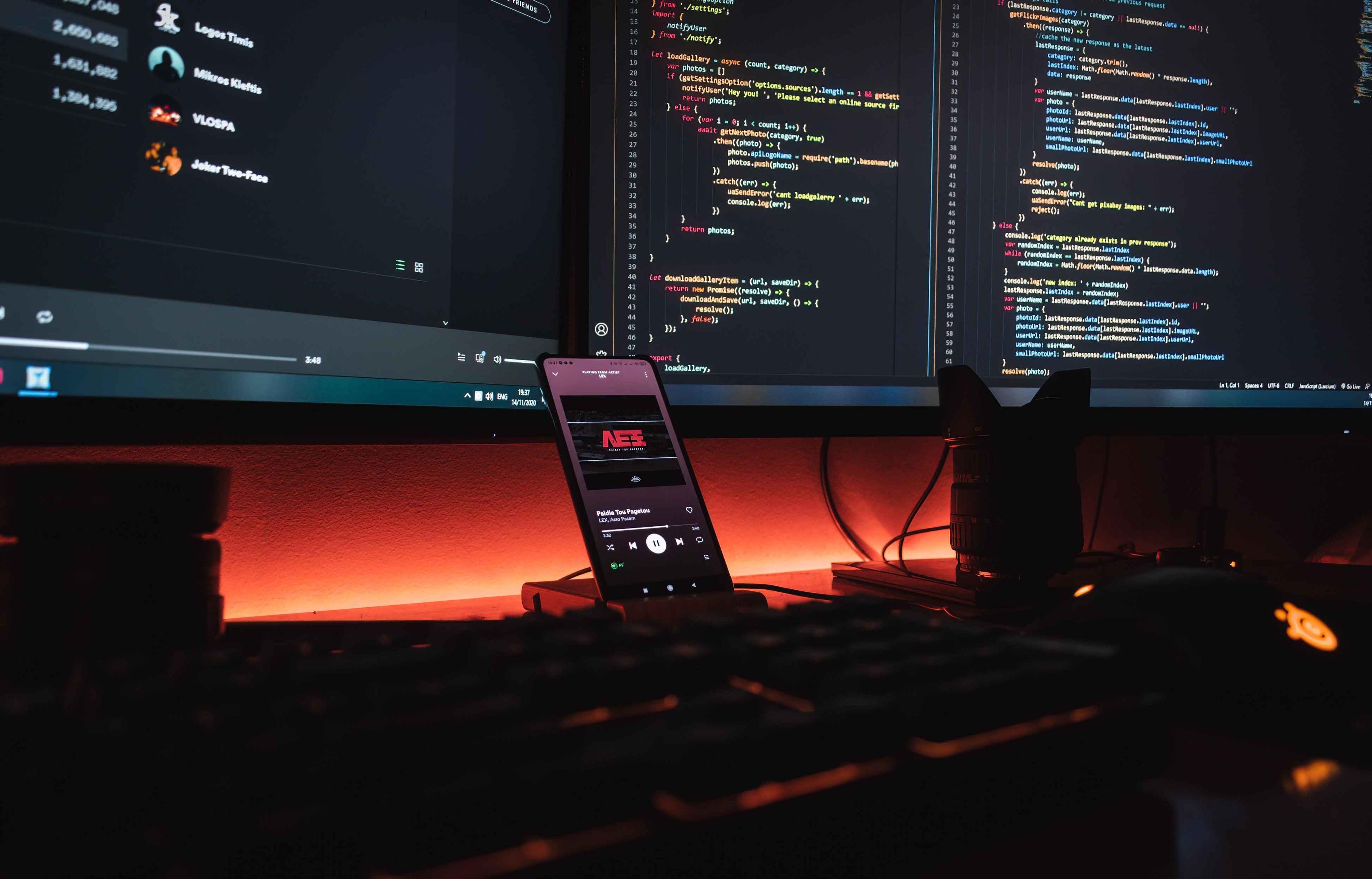 mobile, keyboard and two monitors side by side